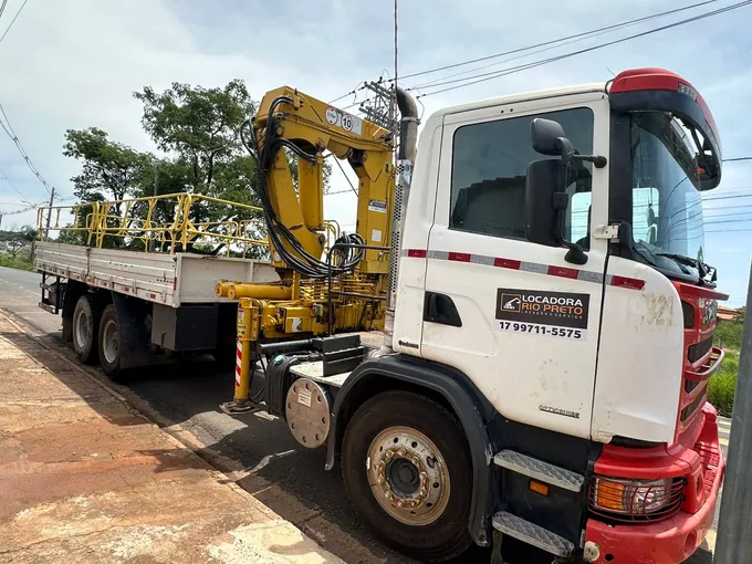 Caminhão Scania G 400 branco da Locadora Rio Preto com guindaste articulado amarelo sobre a carroceria