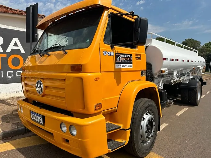 Caminhão pipa Volkswagen 17-210 de cabine laranja da Locadora Rio Preto, com tanque de aço, na rua