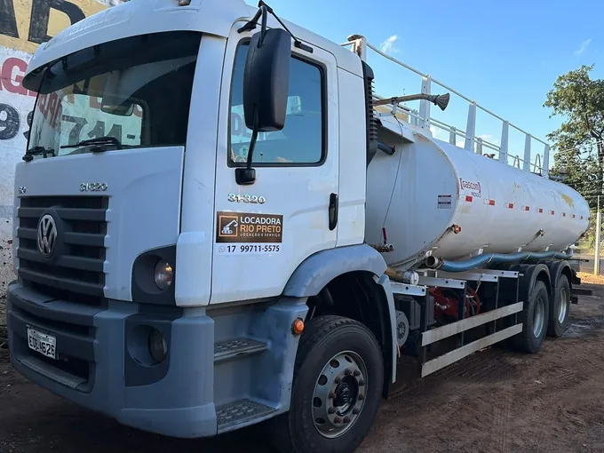 Caminhão pipa Volkswagen branco da Locadora Rio Preto, com tanque de aço e passarela, estacionado em via asfaltada